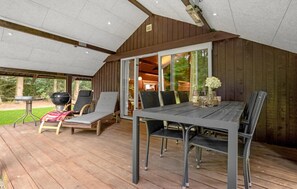 A covered outdoor area with a table and chairs, a grill, and lounge chairs. - 4 bedroom beautiful home in Toftlund (Toftlund)