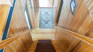 Una escalera de madera con un tapete azul estampado al final.