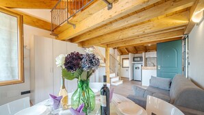 A dining area with a table set for four, a staircase, a kitchen, and a living room with a sofa. - Nice home in Avegno with house sea view (Avegno)