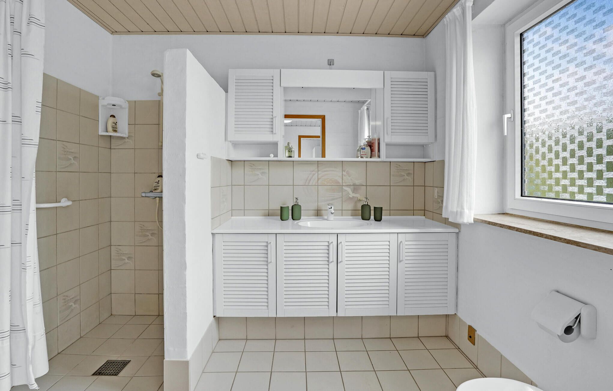 Une salle de bain moderne équipée d’une douche, d’un lavabo et de toilettes.
