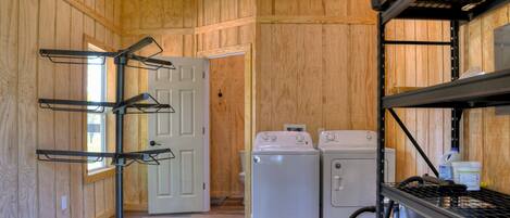 A laundry area with a washer and dryer, metal shelves, and a door leading to another room.