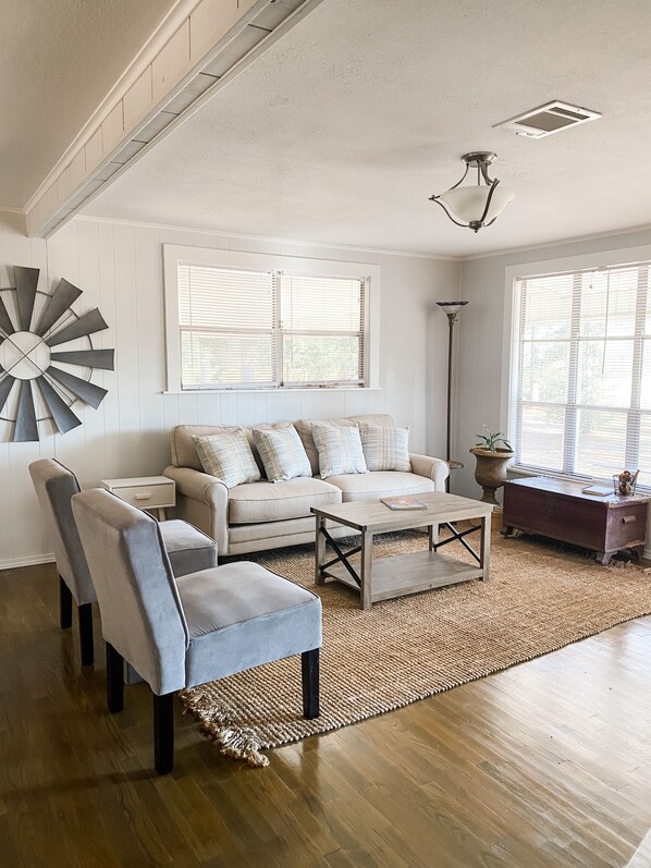 A living room with a sofa, two armchairs, a coffee table, and a floor lamp.