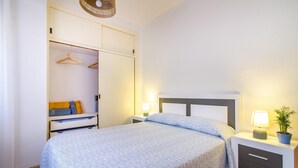 A bedroom with a bed, bedside tables, a wardrobe, and a hanging rack. - Beautiful apartment in San Javier (San Javier)