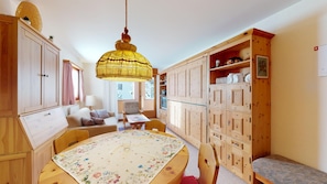 Une pièce chaleureuse avec une table à manger en bois, un canapé et une grande armoire.