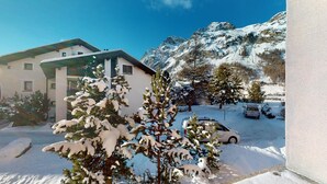 Eine verschneite Berglandschaft mit einem Gebäude und einem Auto.