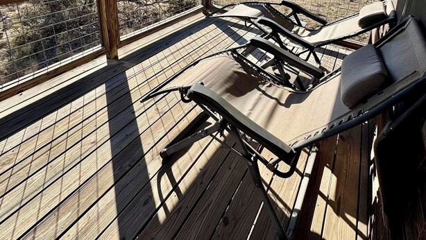 Une terrasse en bois avec des chaises longues et une vue sur un paysage désertique.