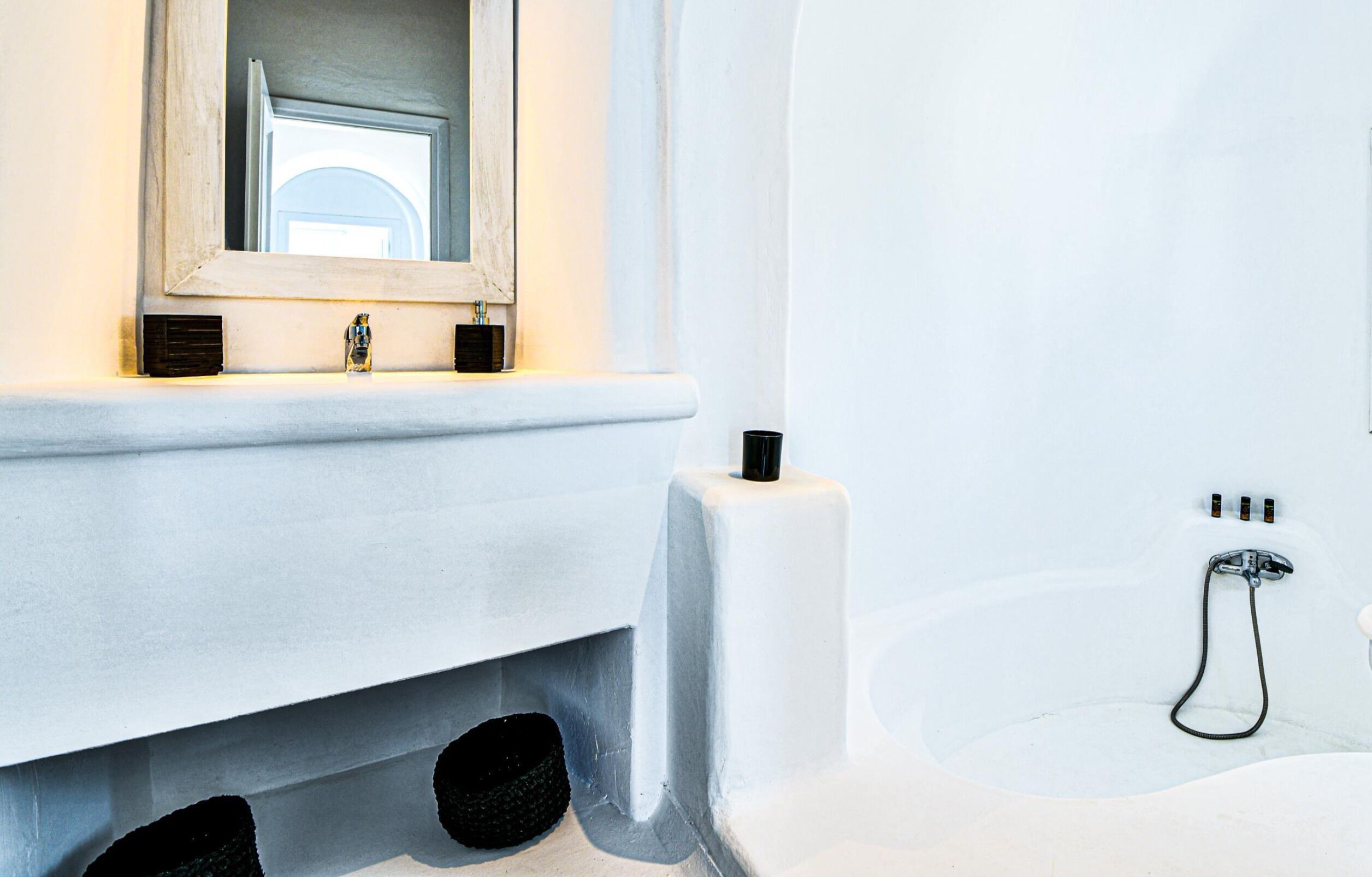 Une salle de bain avec une baignoire blanche, un miroir au-dessus du lavabo et un distributeur de serviettes.