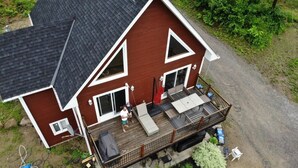 A two-story house with a deck, a covered patio, and a fenced yard. - Waterfront Family Cottage! (Notre-Dame-de-Pontmain)