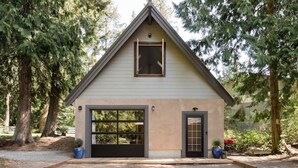 Una casa a un piano con garage, un piccolo portico e un tetto a forma triangolare.