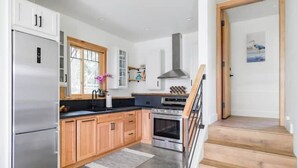 Una cucina moderna con mobili in legno, un frigorifero in acciaio inossidabile e un forno integrato.