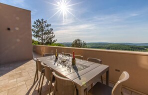 Enjoy al fresco dining on the terrace with a view of the lush landscape.