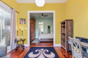 Quarto com uma cama, uma estante de madeira, um tapete decorativo e um quadro na parede.