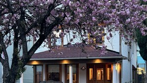 A two-story house with a porch, a staircase, and a well-maintained garden. - The Center of Vancouver, Spacious Elegant Interior, Spectacular Outdoor Living (Vancouver)