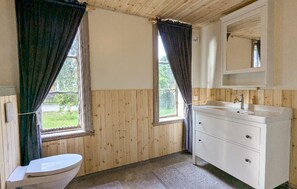 A bathroom with wooden walls, a white sink, and a toilet. - Amazing home in Ringarum with ethernet internet (Ringarum)