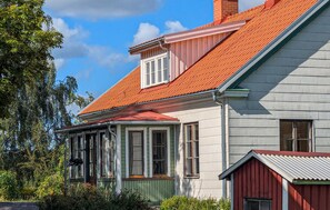 A two-story house with a red-tiled roof, a dormer window, and a small attached shed with a red roof. - Amazing home in Ringarum with ethernet internet (Ringarum)