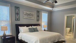 A bedroom with a large bed, two bedside tables with lamps, a dark wooden headboard, and two decorative wall pieces. - Perfect Masters Golf Rental Home - 12 miles from the Augusta National (North Augusta)