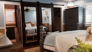 A bedroom with a bed, a dresser, a mirror, and a door leading to another room. - Colorful 2-bdr, 2-bth unique serenity. (Modesto)