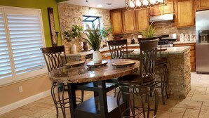 A kitchen with a granite island, wooden cabinets, and a stainless steel refrigerator. - Colorful 2-bdr, 2-bth unique serenity. (Modesto)