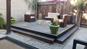 A patio with wicker furniture, a fire pit, and potted plants. - Colorful 2-bdr, 2-bth unique serenity. (Modesto)