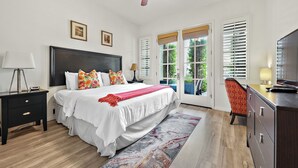 A bedroom with a large bed, a nightstand, a dresser, and a ceiling fan.
