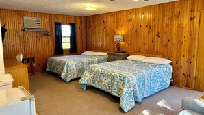 A room with two beds, a ceiling fan, a heater, a window with curtains, and a lamp on a nightstand. - DRIFTWOOD RESORT BULL SHOALS (Bull Shoals)