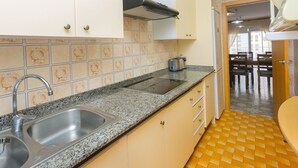 A kitchen with a granite countertop, stainless steel sink, and a toaster. - Beautiful apartment for 4 guests with WIFI, pool, TV and balcony (Santa Susanna)