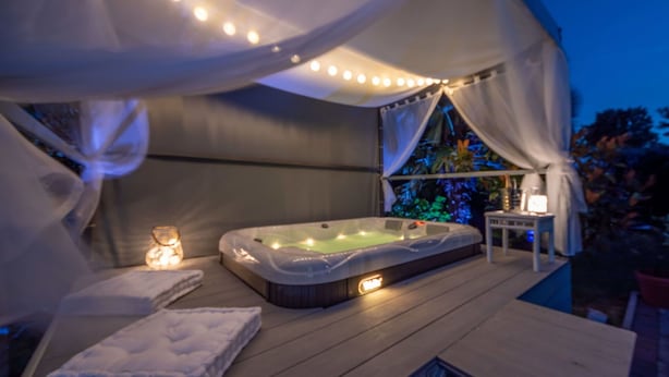 A hot tub with a canopy, surrounded by a wooden deck and a small table with a lamp. - Nice apartment for 4 guests with WIFI, TV and terrace (Rijeka)