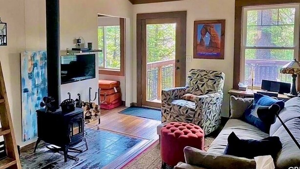 Una sala de estar acogedora con chimenea, un sillón estampado y un sofá.