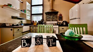 Una cocina moderna con vigas de madera, una estufa y una silla verde.