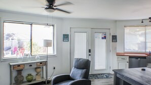 A modern kitchen with a bar area, a seating area with a chair, and a dining table.