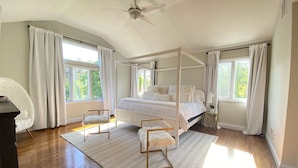 A bedroom with a four-poster bed, wooden flooring, and large windows with curtains. - 5BR, Luxury Home, Pool, Large Yard , Close to Beach & Town (Southampton)