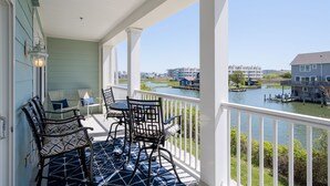 A covered balcony with a view of a river and buildings. - Sunset Island Condo, Indoor/Outdoor Pools, FREE Linen/Towel Pkg, Parking for 2 (Ocean City)