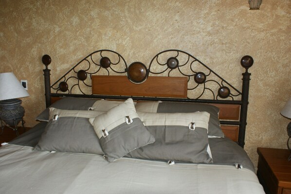 A bed with a wooden headboard and multiple pillows.