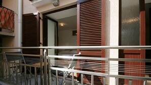 A balcony with metal railings, a table, and chairs.