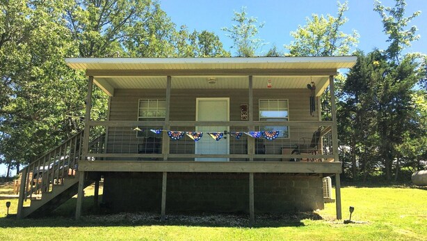 A two-story building with a covered deck and a staircase leading to the upper level.