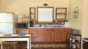 A compact kitchen with wooden cabinets, a microwave, a toaster, and a sink.