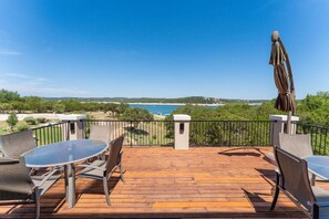 Enjoy the serene sea views from this deck, surrounded by comfortable seating and a stylish umbrella.