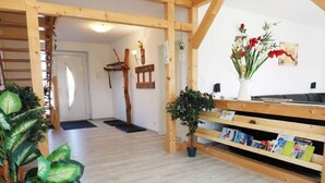En inredning med träpanel, en träbänk, en krukväxt och en hylla med böcker.