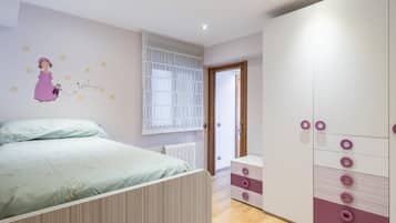 Een slaapkamer met een bed, een kledingkast en een decoratie aan de muur.