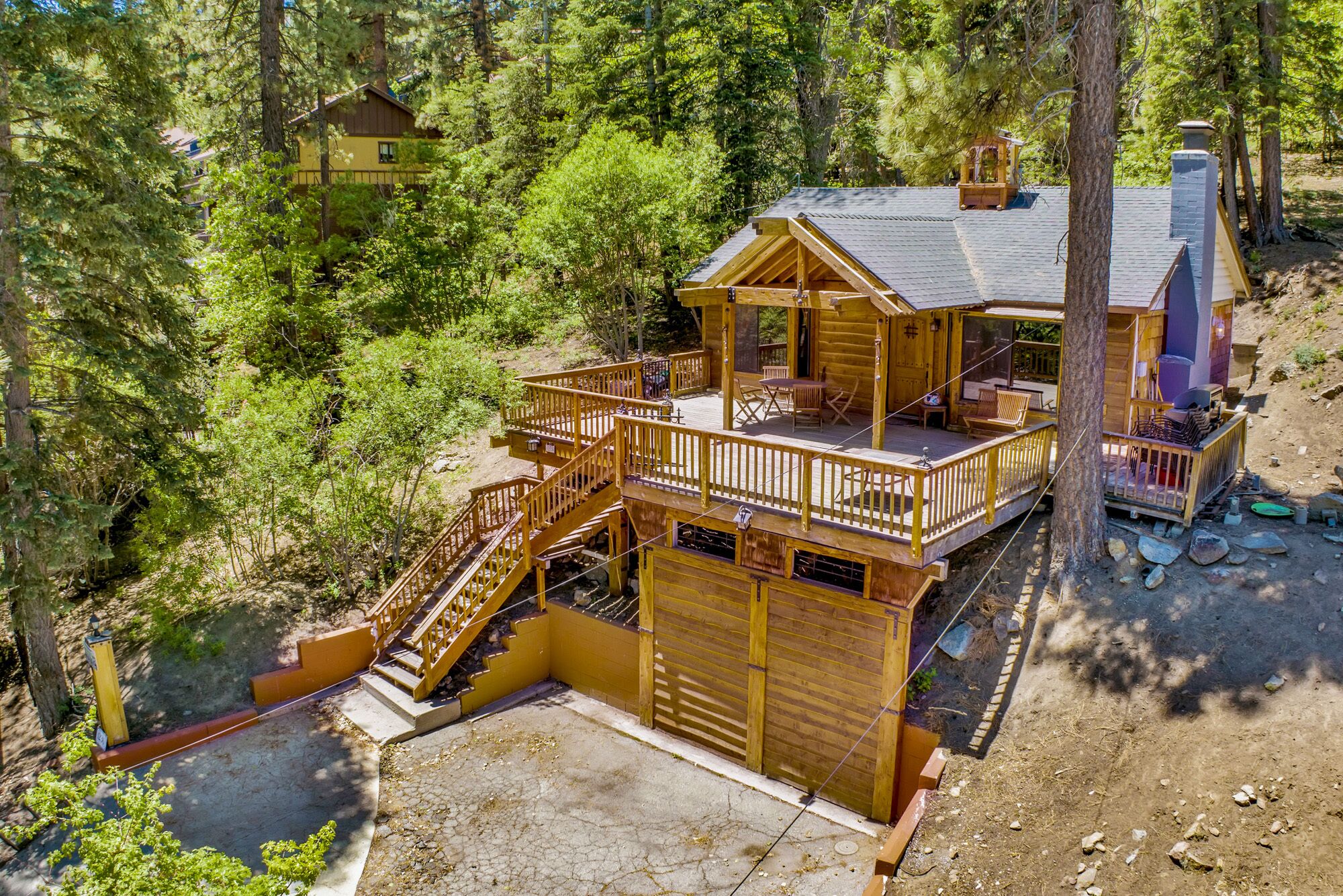 Welcoming cabin entry surrounded by towering pine trees, offering fresh mountain air and a peaceful forest setting—the perfect first impression for your Big Bear Lake getaway.