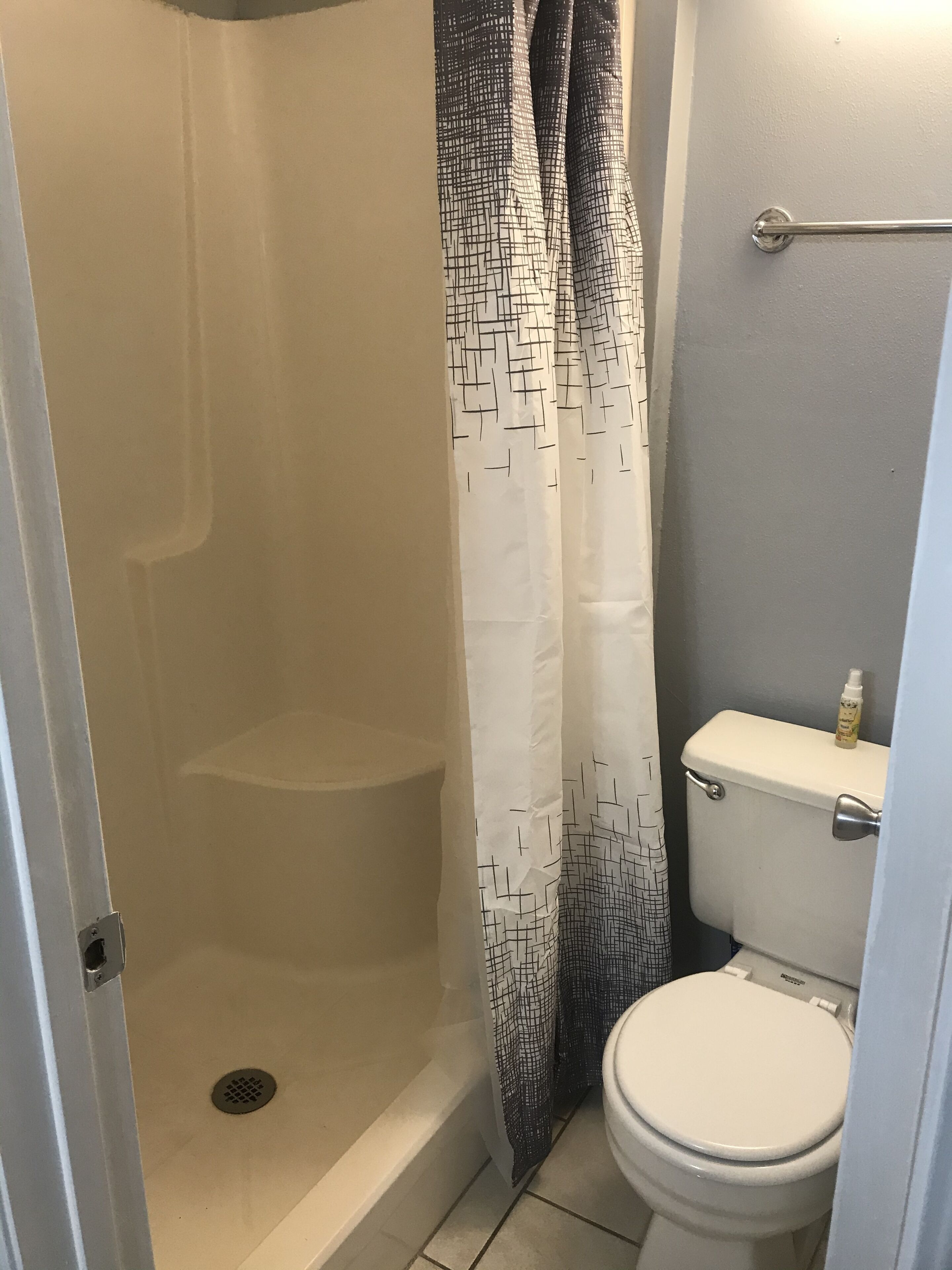 Ein Badezimmer mit Dusche, Toilette und Handtuchhalter.