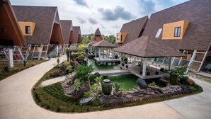 A modern residential complex with multiple houses featuring sloped roofs and a central courtyard with a water feature.