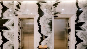 An elevator with marble walls and a wooden base. - Goldberry Suites and Hotel Cebu (Cebu City)