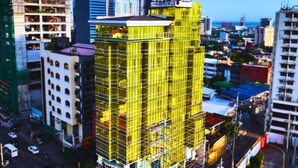 A multi-story building with a yellow facade, surrounded by other buildings and a busy street. - Goldberry Suites and Hotel Cebu (Cebu City)