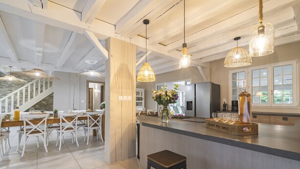 A modern kitchen with a central island, bar stools, and hanging pendant lights. - Property with indoor pool 15min DISNEYLAND (Crécy-la-Chapelle)
