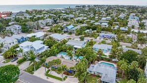 A residential area with houses, some with pools, and a view of the ocean. - Blue Egret: Pool, Enclosed Lanai, Close to the Beach by Anna Maria Life Vacation Rentals (Holmes Beach)