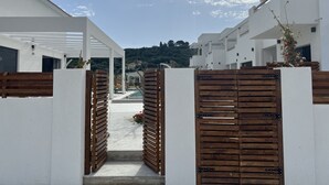 A modern building with a white exterior, a wooden gate, and a clear sky. - Kimiro Hotel Tsilivi (Zakynthos)