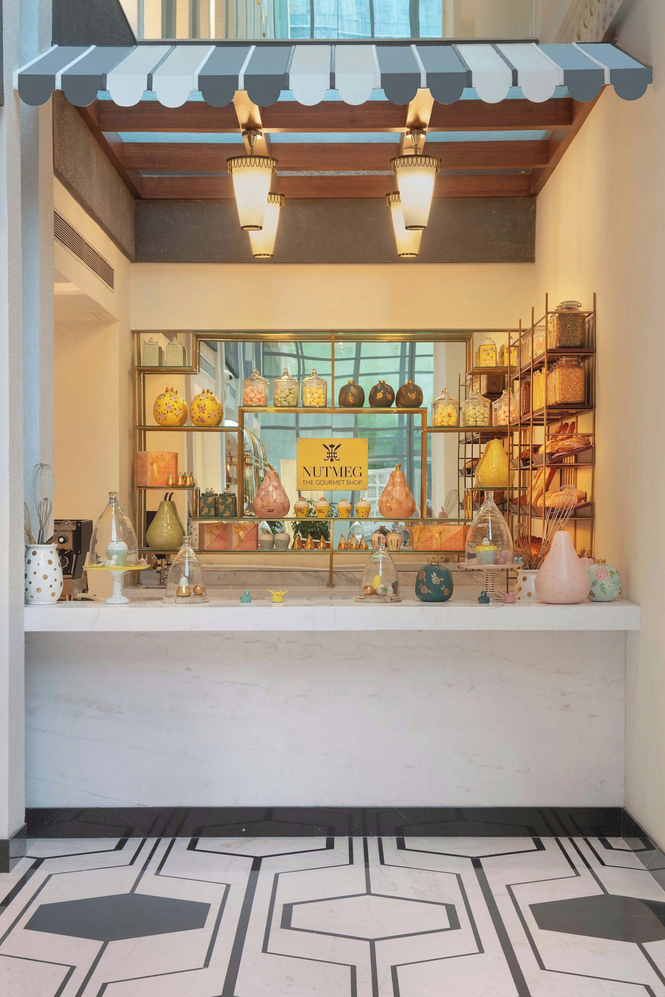 A storefront with a sign reading "NUTTEG THE GOURMET SHOP," displaying various kitchenware and decorative items.