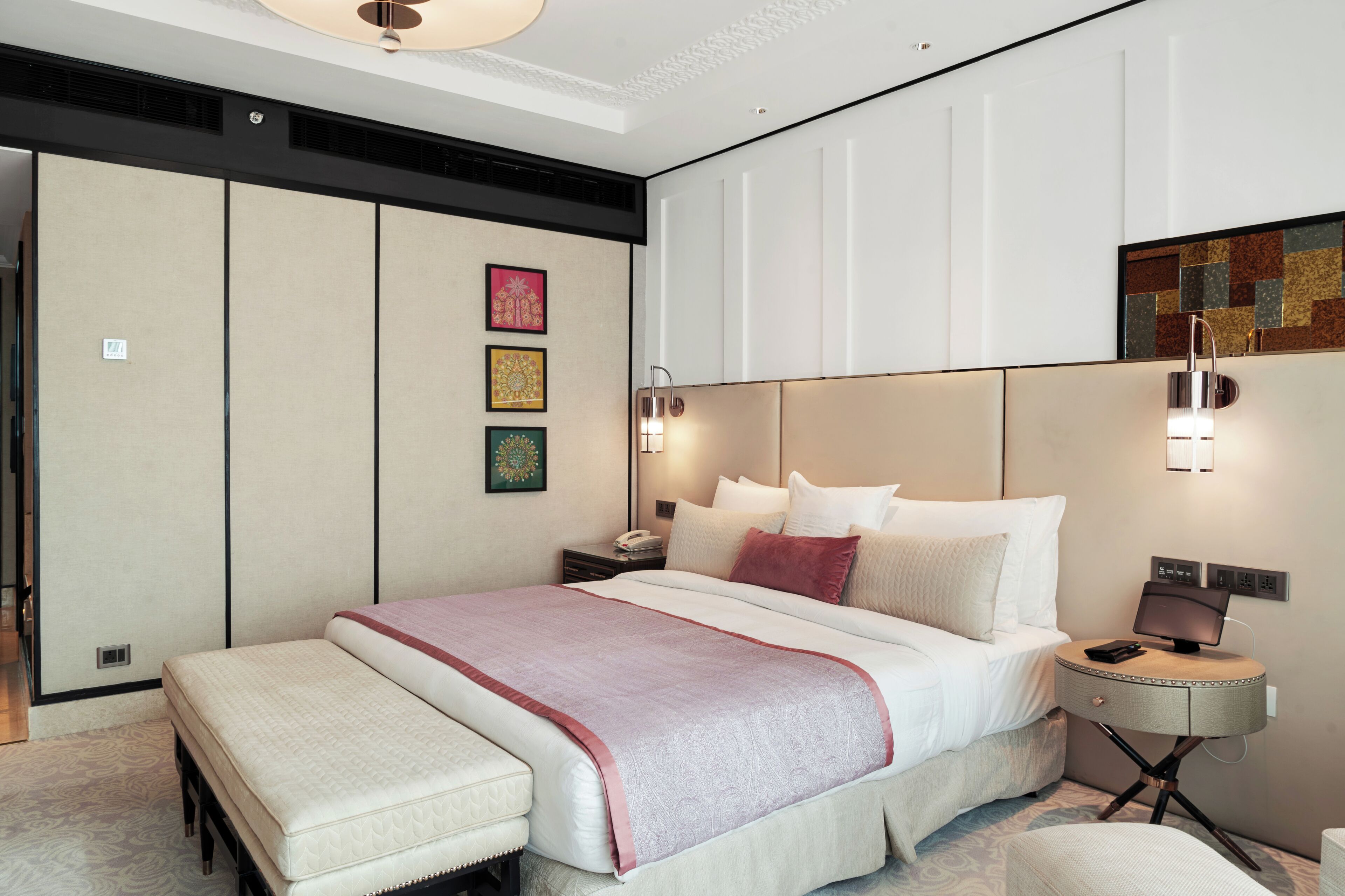 Una habitación de hotel moderna con una cama grande, mesitas de noche y un televisor montado en la pared.