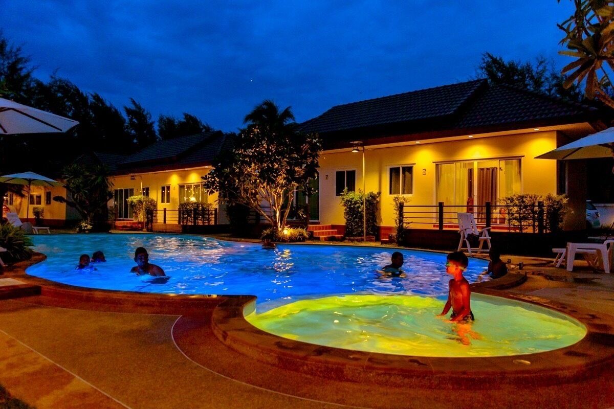 Schwimmbadbereich im Dämmerlicht, Personen schwimmen und entspannen.